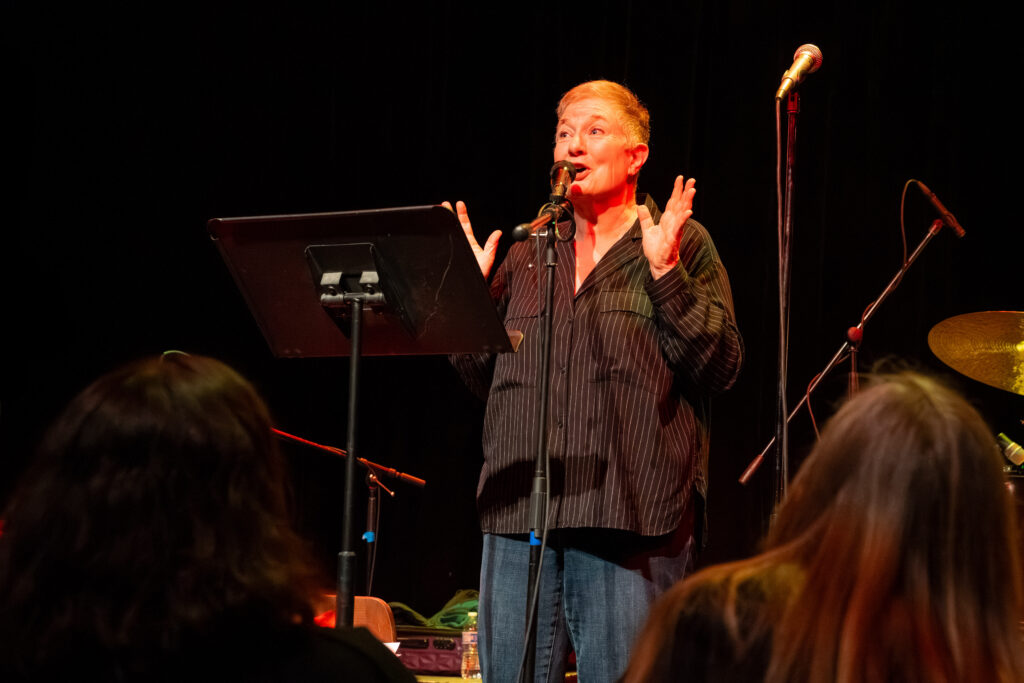 Mary Jo Pehl speaks into a microphone