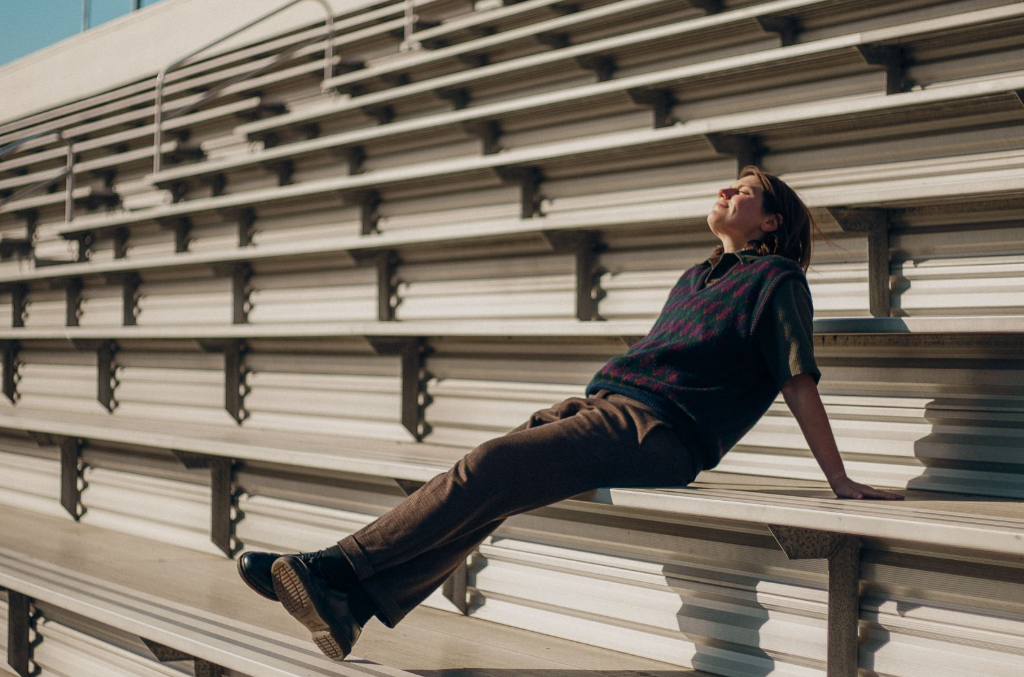 Alex Lahey sits on some bleachers.