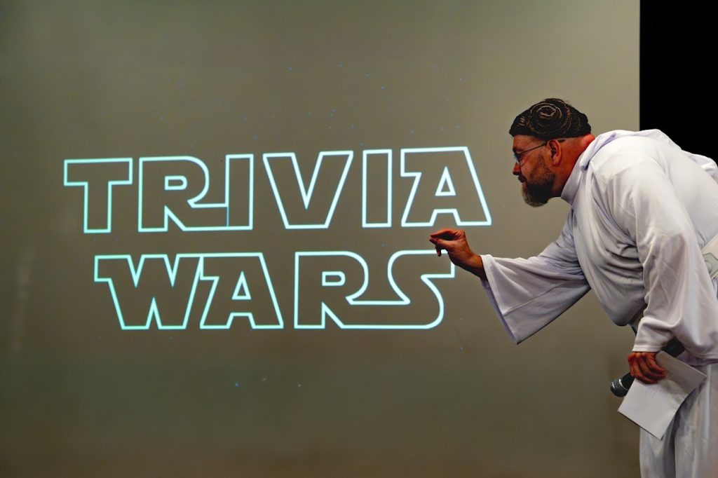 Jim Gray dressed as Princess Leia from "Star Wars" crouches on stage