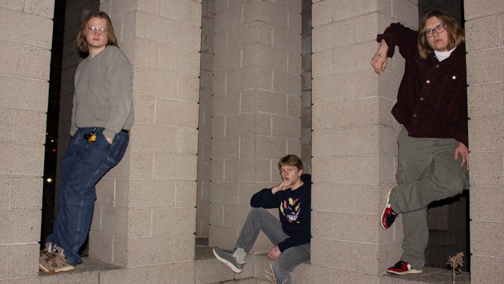 The three members of PSA pose by concrete pillars