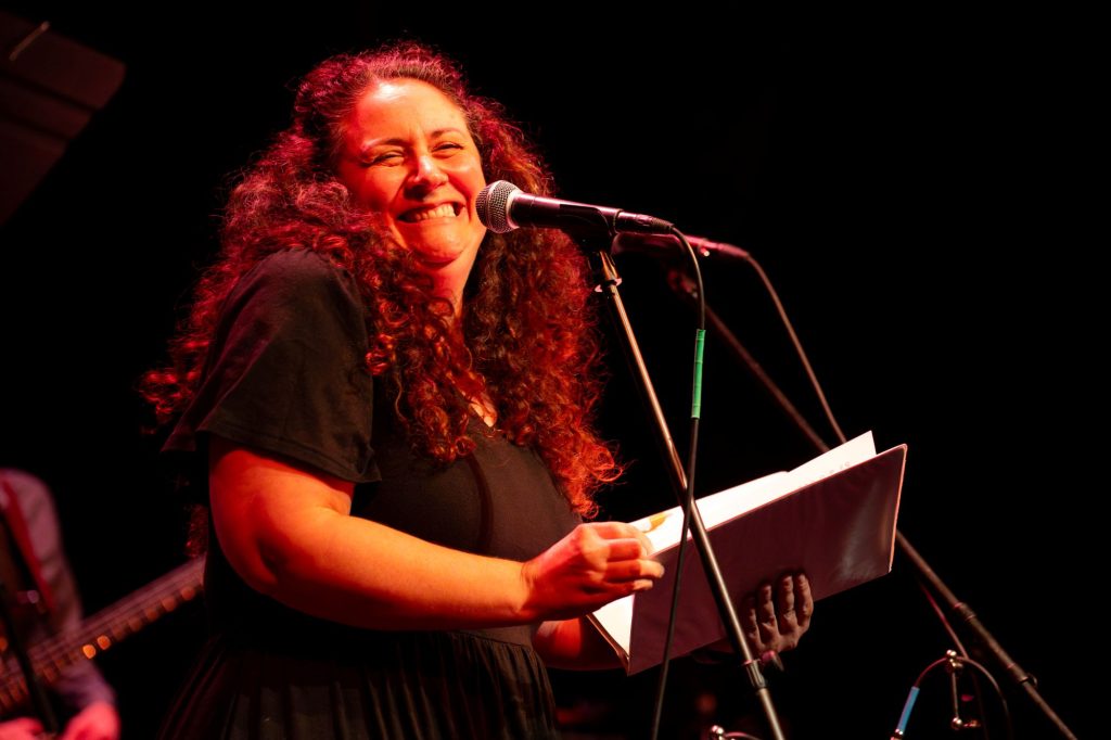 Heather Mastromarco smiles behind a microphone